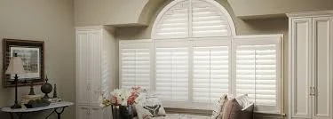 The image shows a large window covered with white blinds, allowing natural light to enter the room.